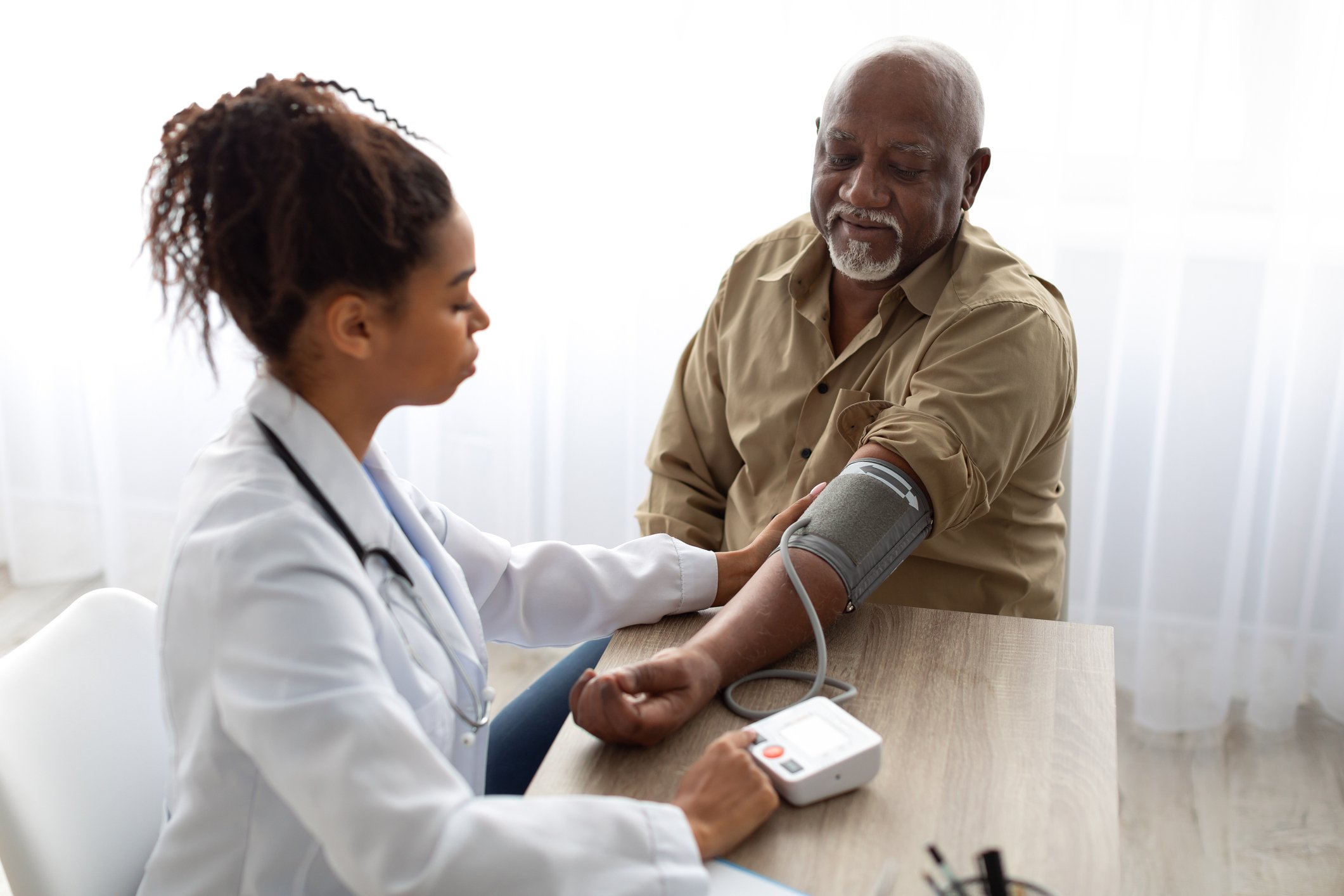 doctor checking measuring blood pressure on patient's hand