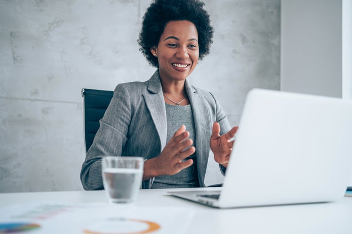 A person at a laptop, smiling. 