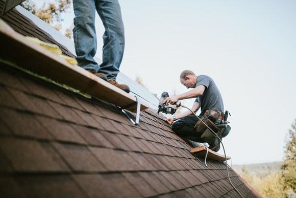 Builders working on the roof of a house.