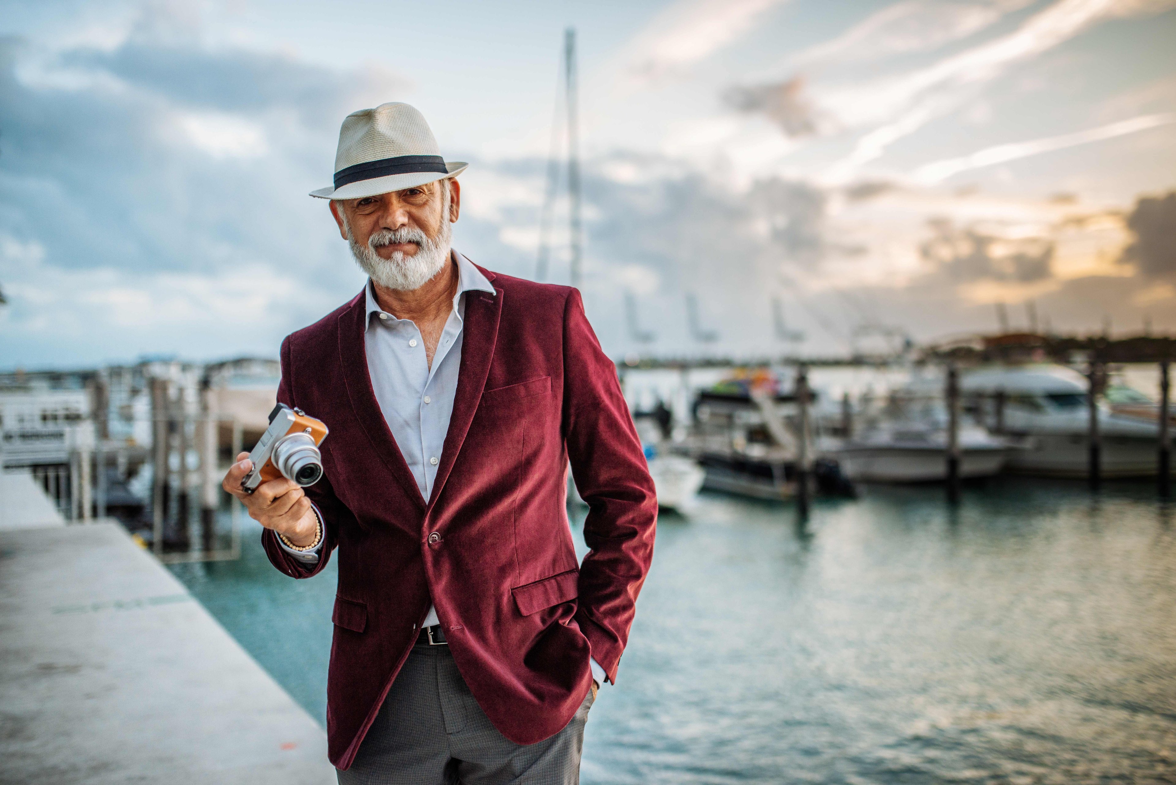older man camera travel retire hat vacation boat harbor wealthy rich