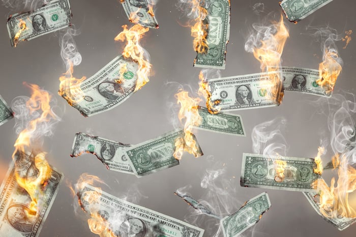 $1 bills on fire and raining down.