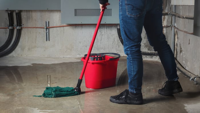 Person cleaning up a flooded basement.