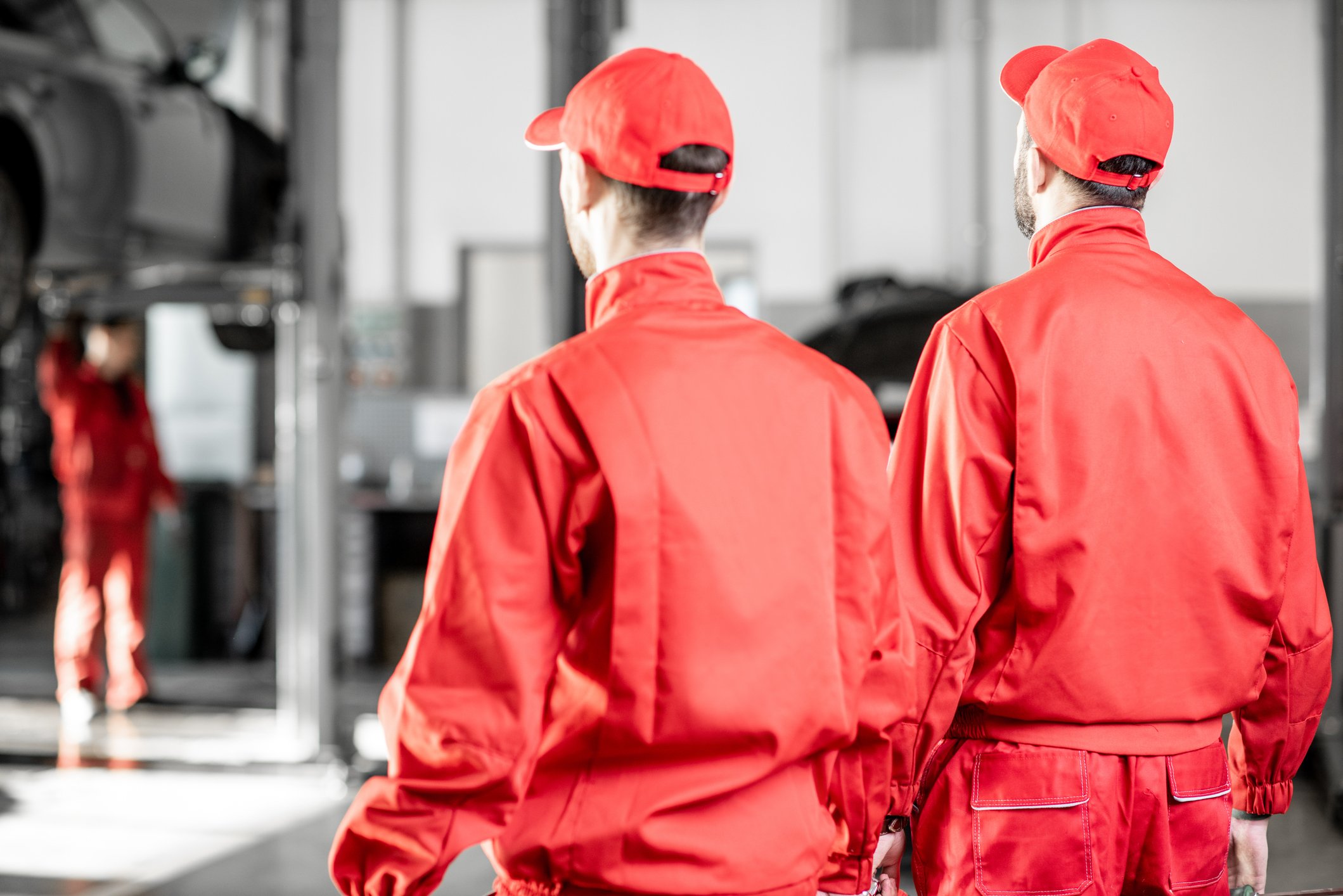 23_07_25 Two people in bright red uniforms in an auto shop _MF Dload
