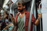Traveler using mobile phone while riding a subway train