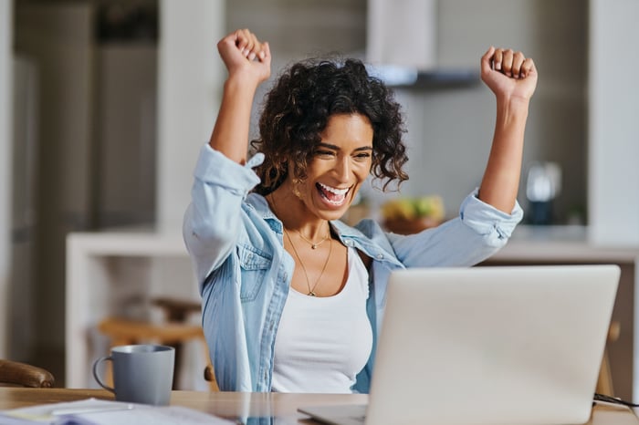 Excited person looking at computer screen. 