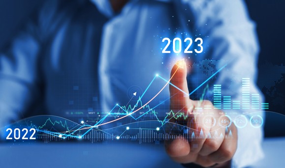 A person pointing to a rising chart from 2022 to 2023.
