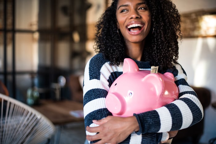 A person hugging a piggy bank.