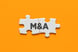 22_04_25 Connected puzzle pieces with the letters M&A on them _GettyImages-1318465425