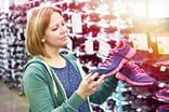 woman shopping for sneakers at store