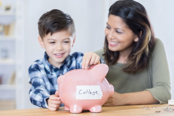 parent and child saving for college in a piggy bank.