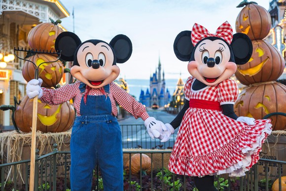 Mickey and Minnie Mouse in fall decor at Disney World's Magic Kingdom.