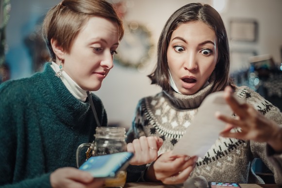 Two shoppers checking a receipt.