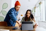 two people looking at a laptop