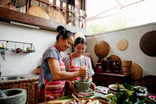 Two people working together in a kitchen in an Airbnb experience.