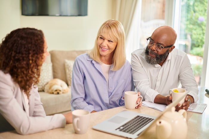 Two people consulting with a third person.
