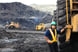 21_05_18 A person in protective gear standing by a giant truck in a mine site _GettyImages-509610535