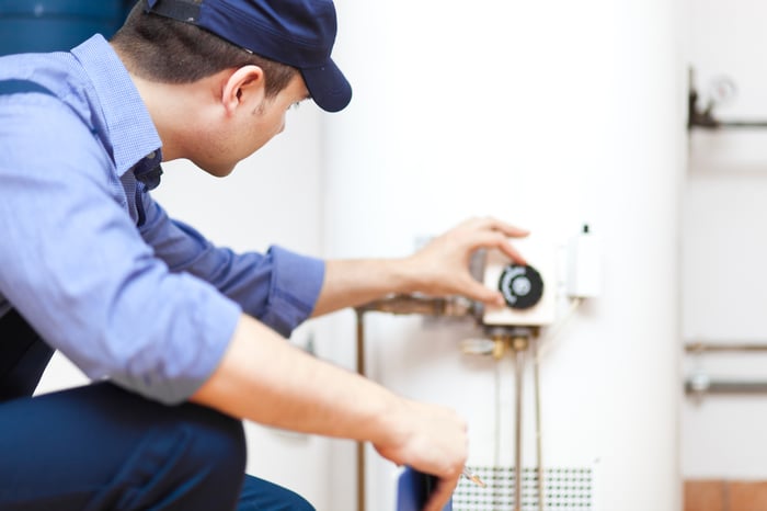 A technician fixing a water heater.