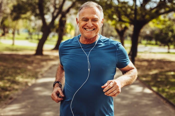 Someone jogging while wearing wired headphones.