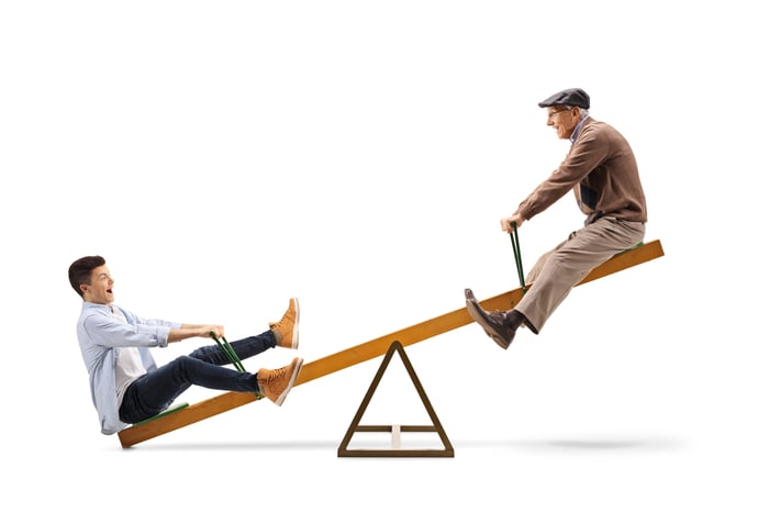 Two people riding a seesaw.