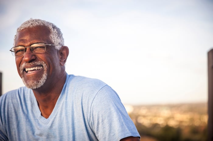 A smiling person outdoors.