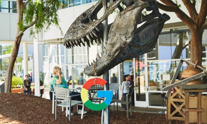 tyrannosaurus skeleton with a Google logo hanging from it. 