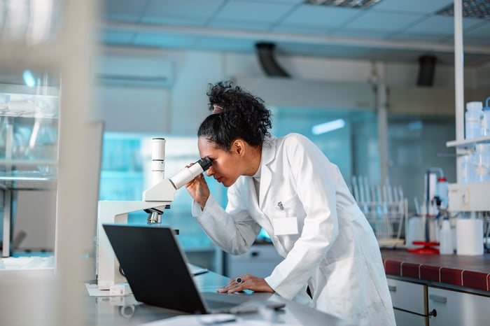 A researcher using a microscope.