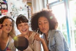3 people looking in a mirror and putting on makeup