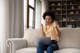 Person excited with a laptop in a home