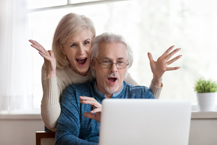 Two excited people at a computer.