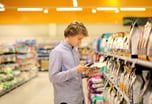 young man shopping in snack aisle of grocery store -- supermarket retail
