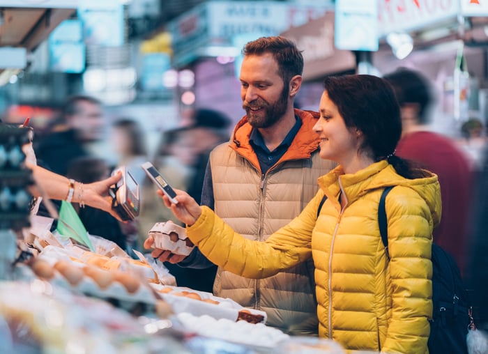 Person paying cashier with a smartphone.