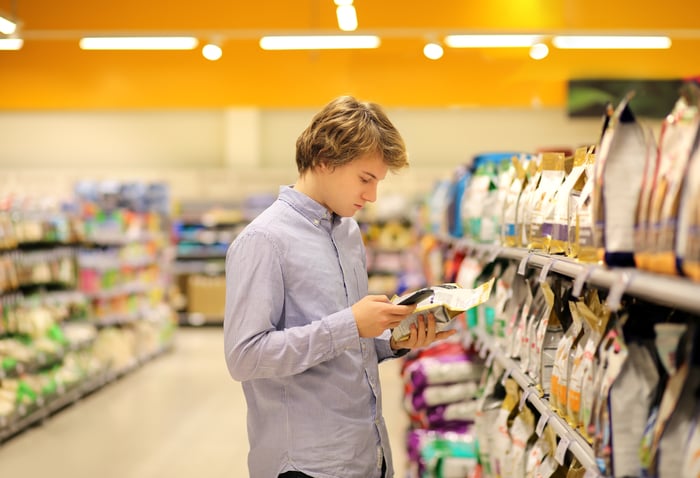 A person shopping in snack aisle of a grocery store.