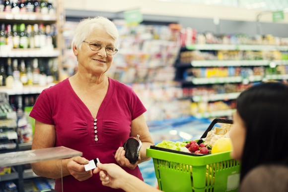 A person purchasing groceries at a checkout counter.