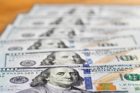 Six one hundred dollar bills staggered atop one another.