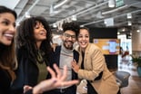 Several people in an office laughing