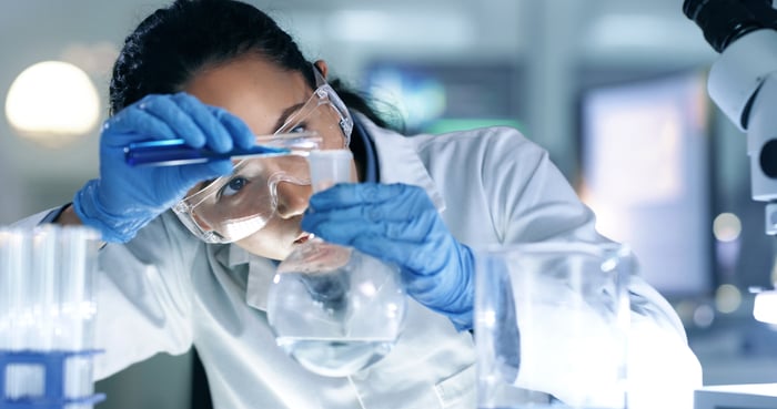 A scientist working with a flask and beaker.