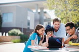 college students young adults millennials using laptop outside