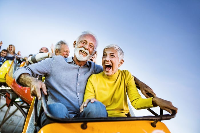 Seniors having fun riding a roller coaster at an amusement park.