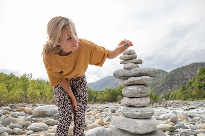 A person stacking rocks.