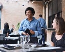 Waitress with a Toast POS device in a restaurant