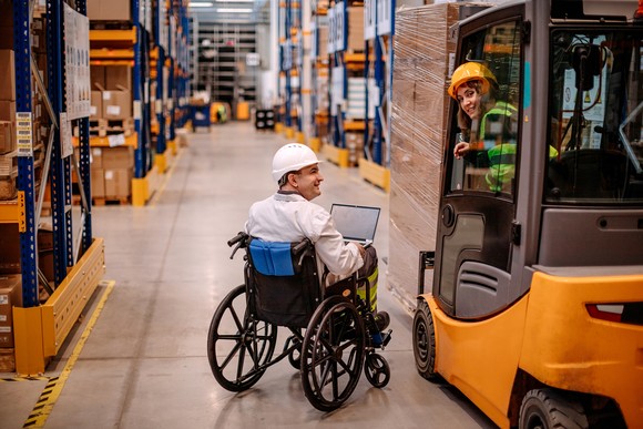 Worker in wheelchair in a warehouse.