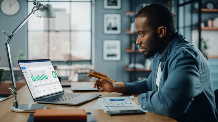 A person looking at a chart on a laptop.