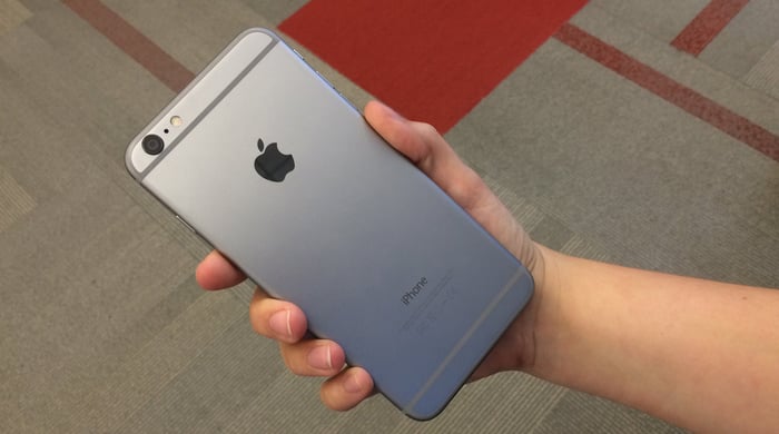 A hand holding an iPhone.