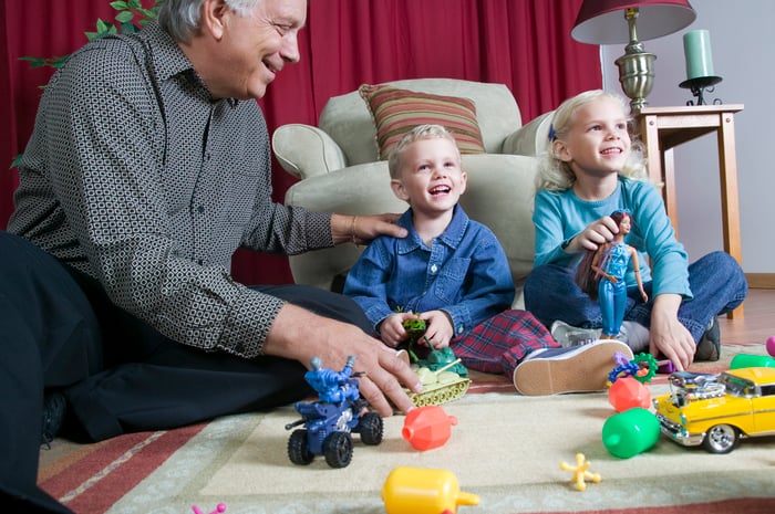 A person sitting on the floor with two children.