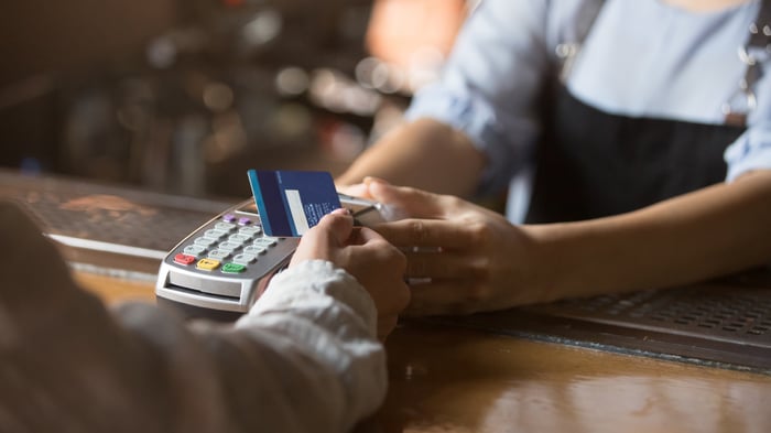 A person paying with a credit card at checkout.