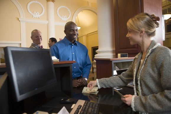 A person deposits cash with a bank teller.