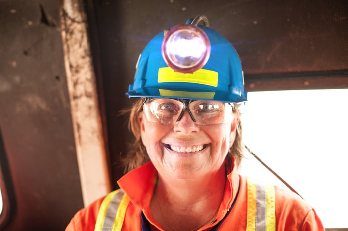 A person in protective gear including a helmet mine light.