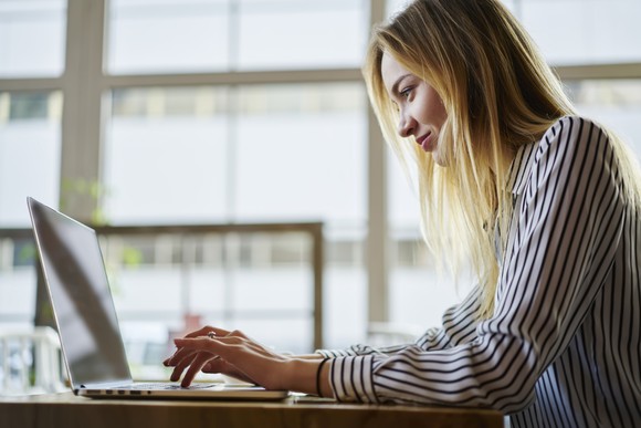 Person typing on a laptop in an office.