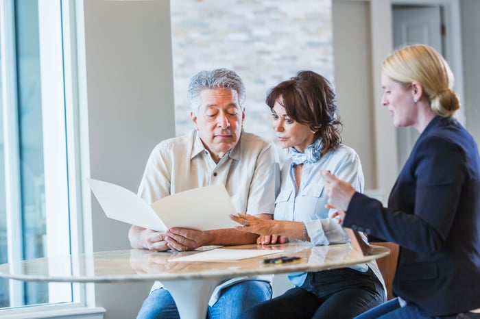 Couple talking with investment advisor.