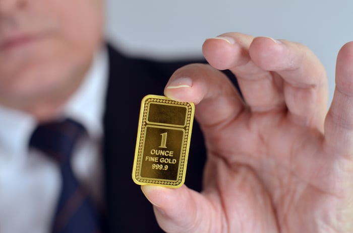 A person holding a gold ingot.